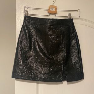 Black patent leather skirt with a slit.